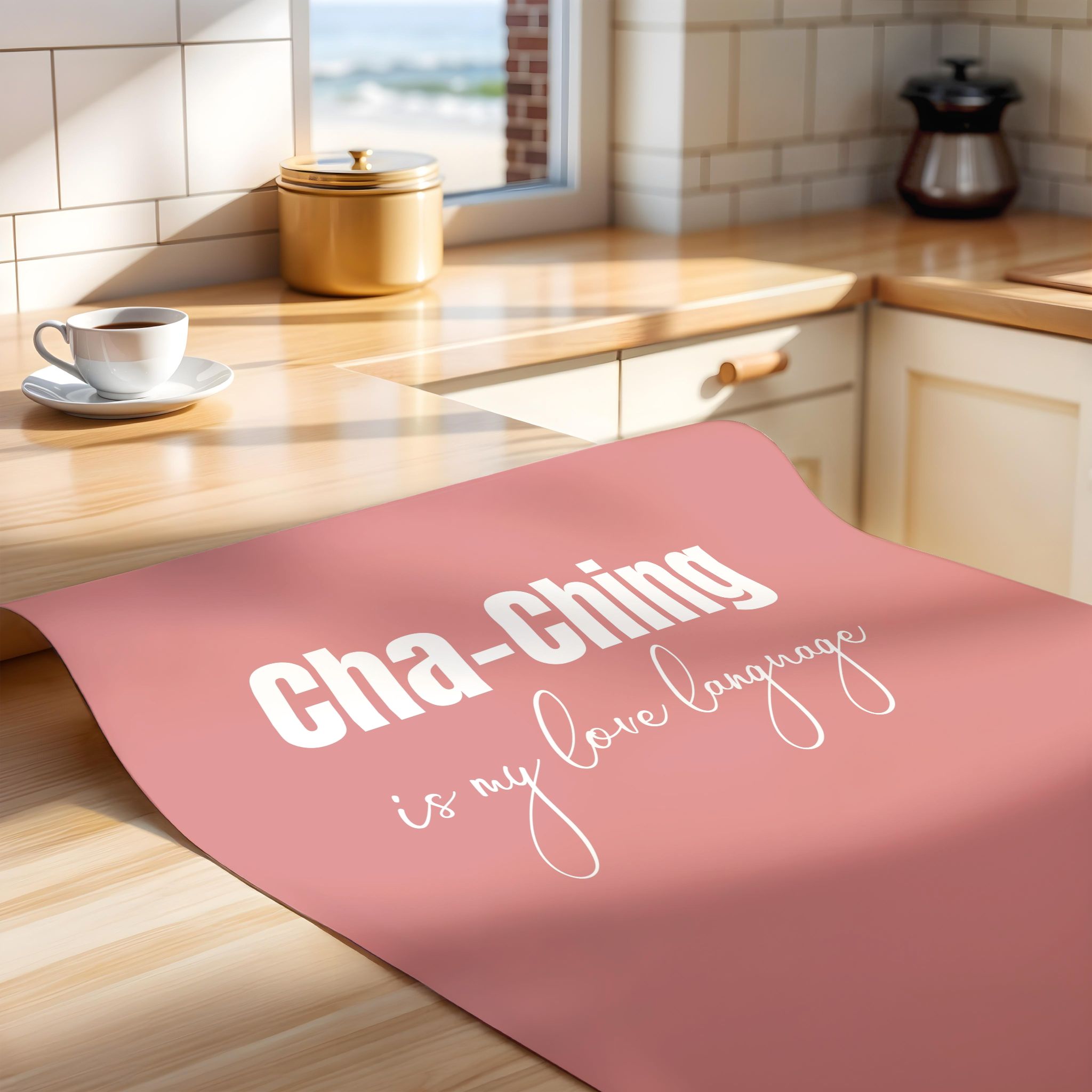 Unframed pink poster on a kitchen counter with 'Cha-Ching is my love language' text