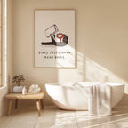 Bathroom interior with a bathtub, plant, and framed artwork on the wall with text 'Girls Just Wanna Read Books'