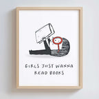Framed artwork with a black and white illustration of a girl with large red glasses, holding a book, with text 'Girls just wanna read books' on a white background.