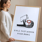 Smiling woman holding a framed print with a black and white illustration and text 'Girls Just Wanna Read Books'.
