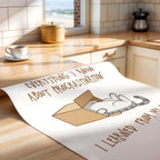 Unrolled poster with a cat illustration and text on a kitchen counter.