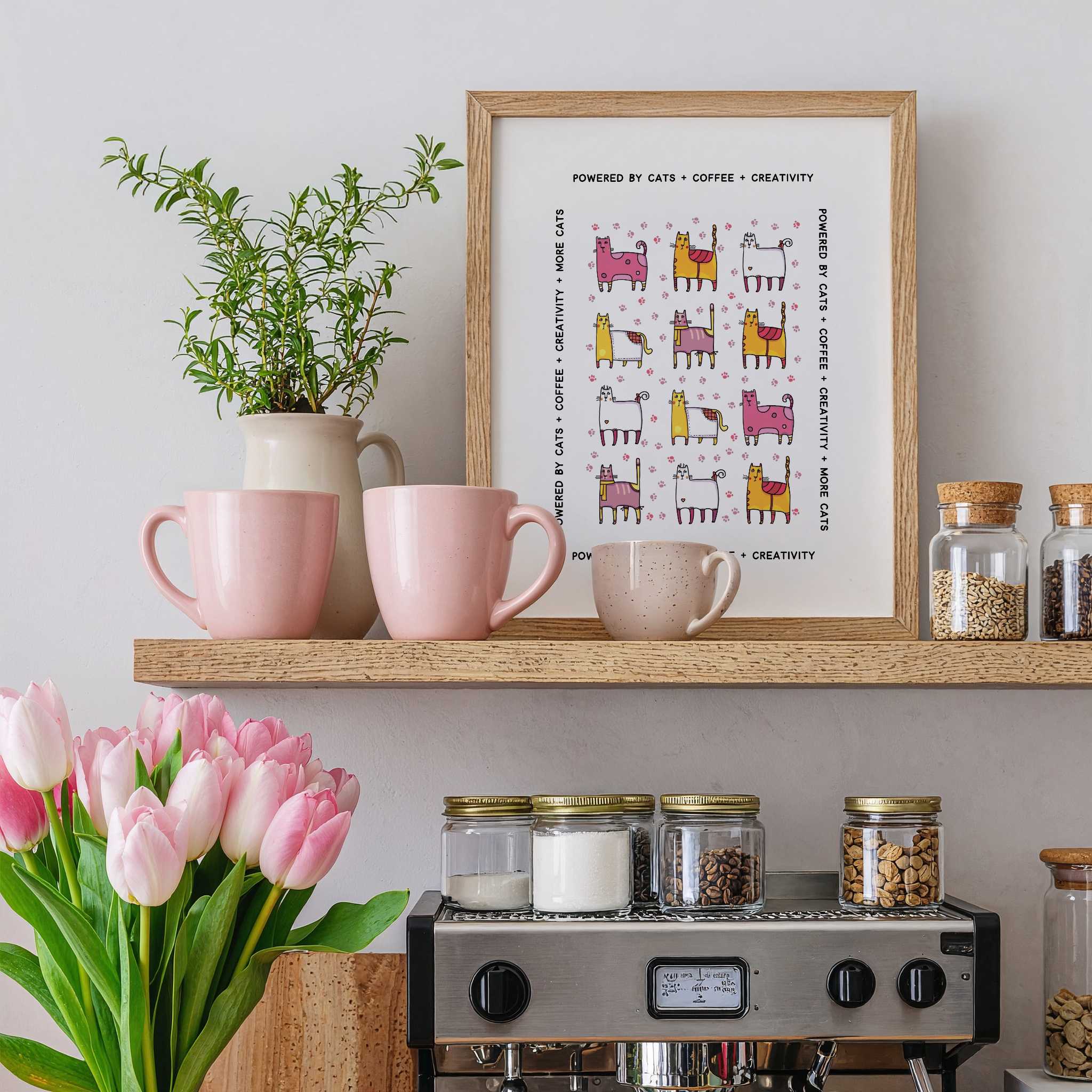 Shelf with pink mugs, a plant, a framed whimsical cats + coffee print, and jars above a coffee machine