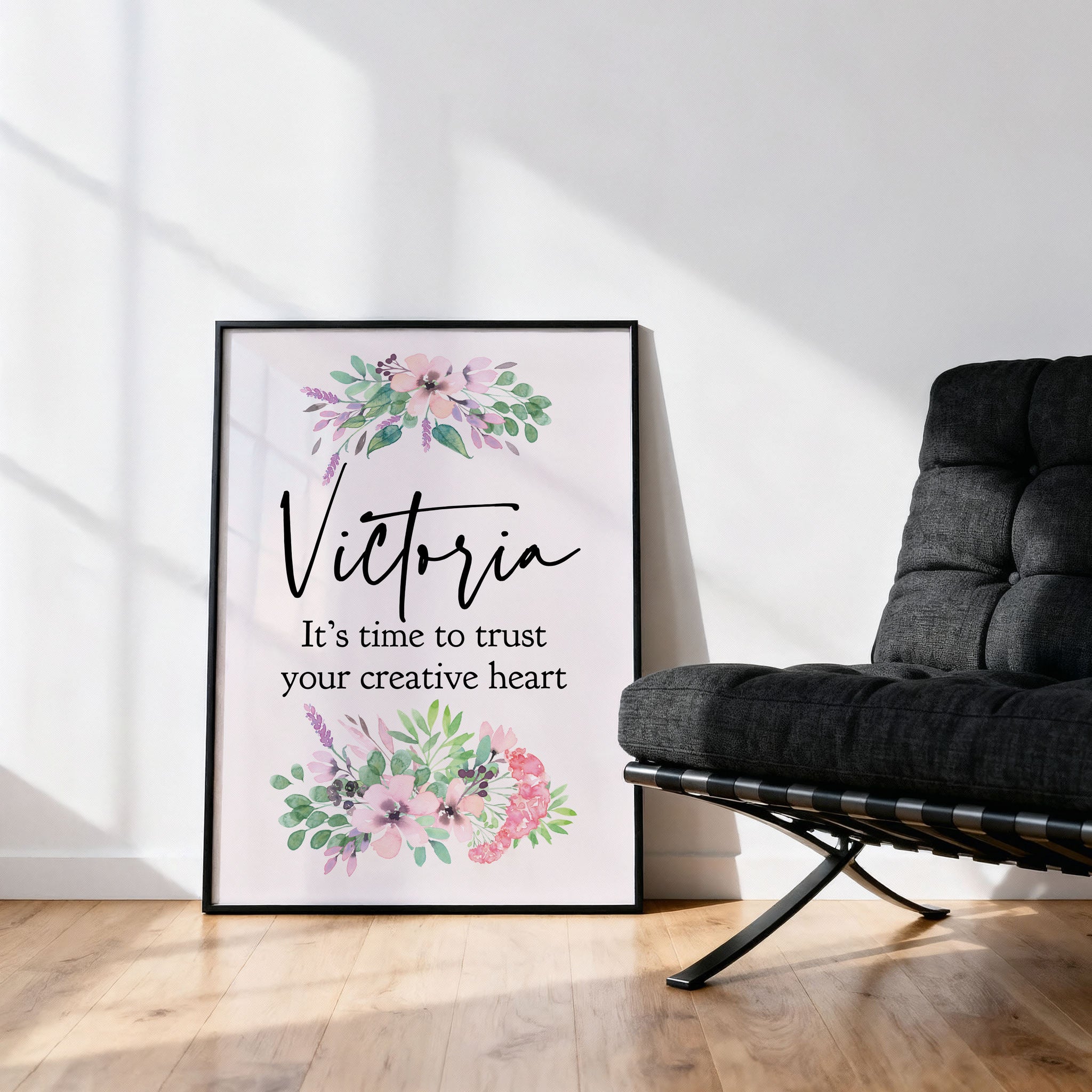 Framed artwork with floral designs and text in a room with a black chair.