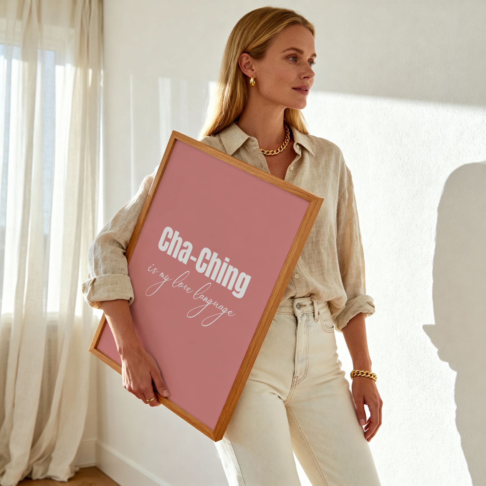 Woman holding a framed pink poster with text in a bright room