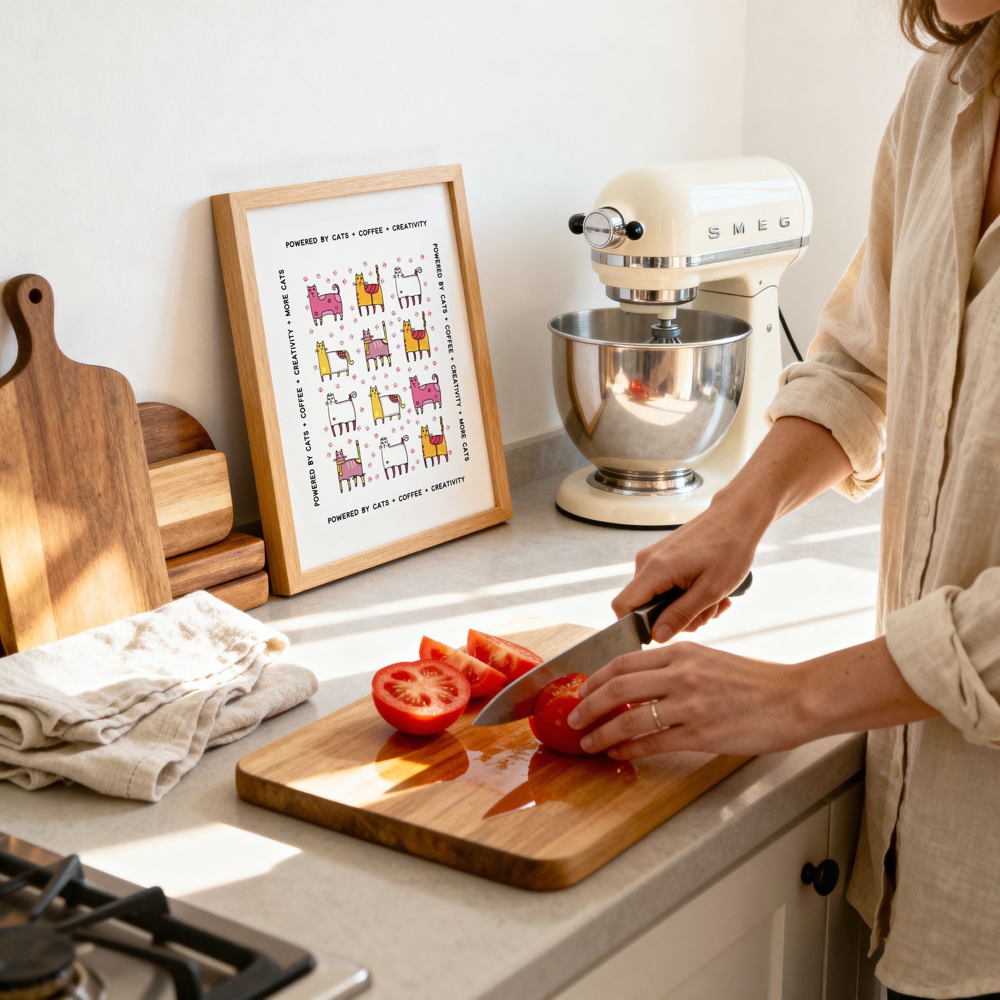 Person cutting tomatoes on a wooden cutting board in a kitchen with a mixer and framed picture in the background.