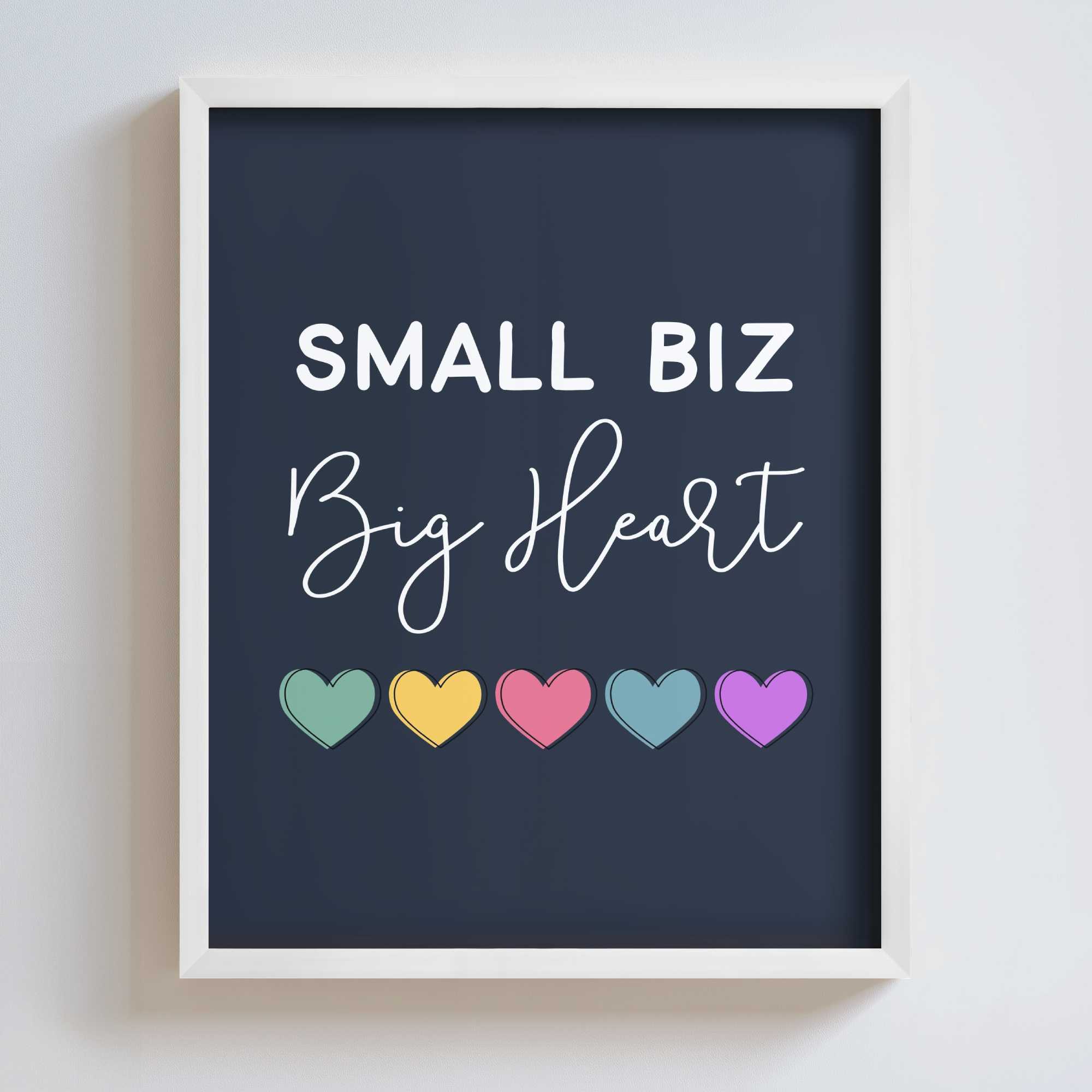 Framed artwork with 'Small Biz Big Heart' text and colorful hearts on a dark navy background.