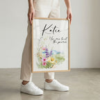 Person holding a framed print with floral design and text