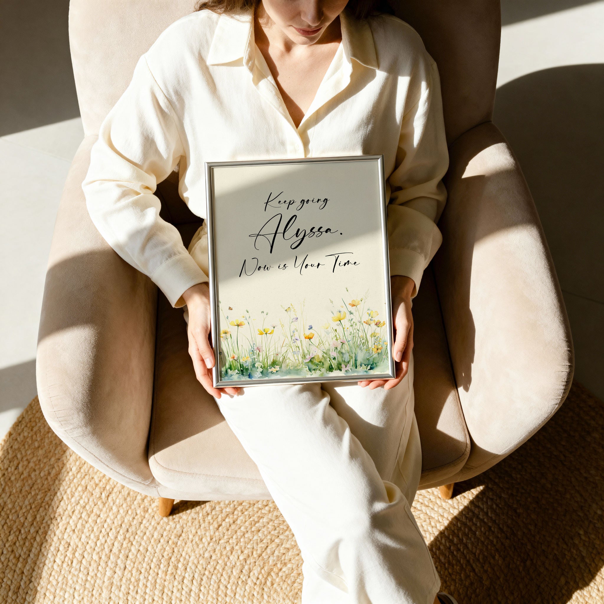Woman holding a framed motivational quote in a silver frame