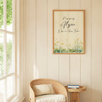 Botanical motivational art on a pale yellow wall above a wicker chair next to a window