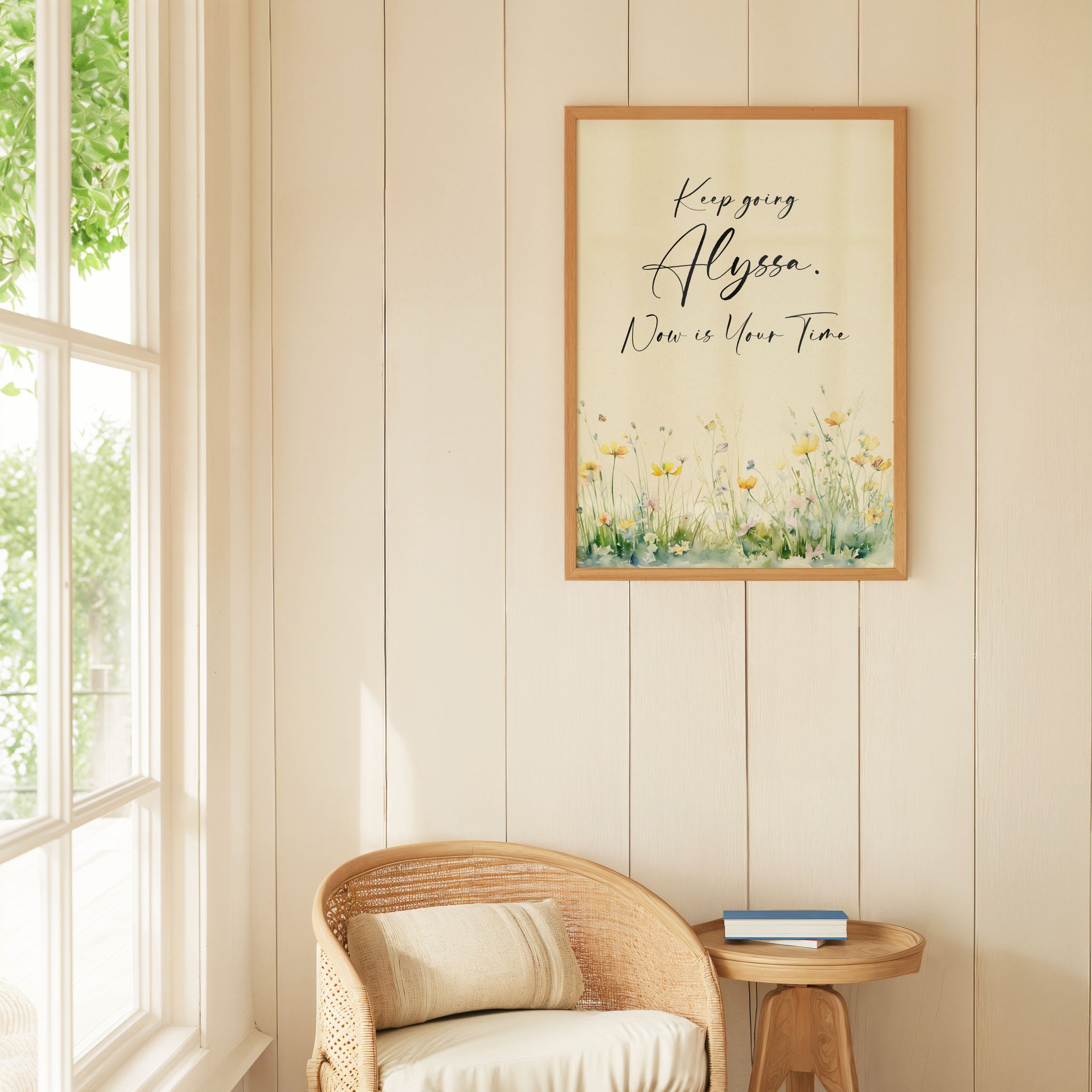 Botanical motivational art on a pale yellow wall above a wicker chair next to a window