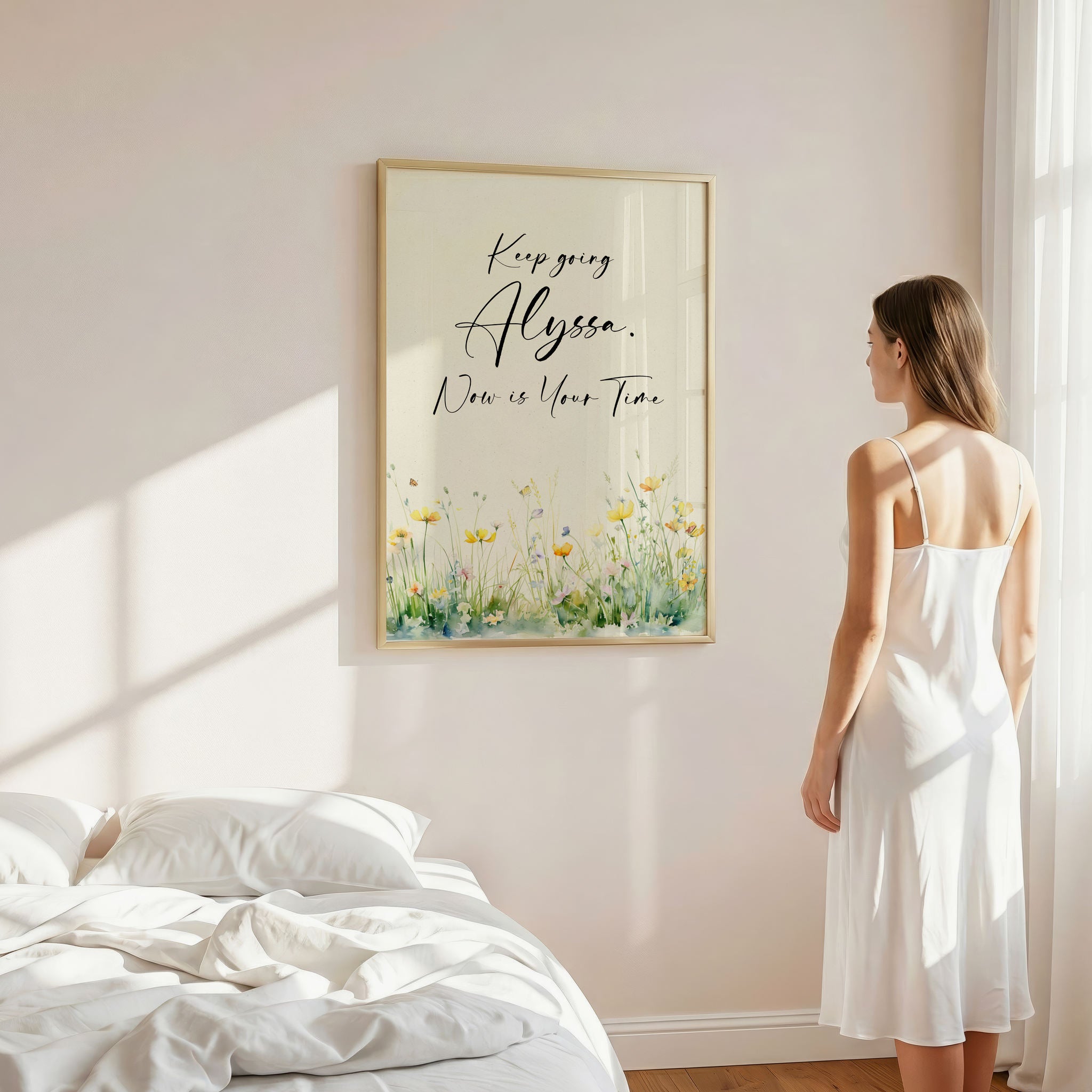 Young woman in a bedroom gazing at a pretty framed motivational art work.